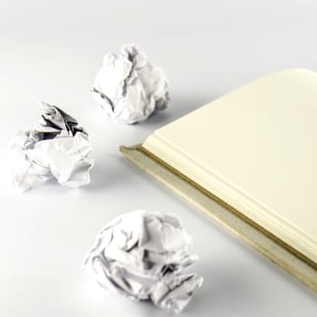 crumpled paper and notebook on a white background