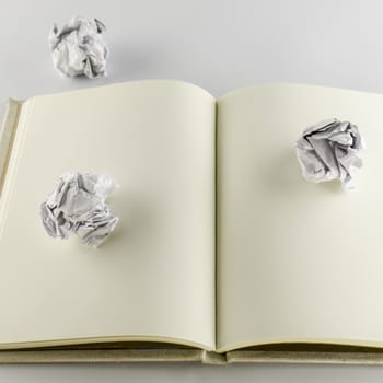 crumpled paper and notebook on a white background