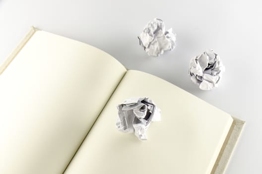 crumpled paper and notebook on a white background