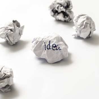 white crumpled paper ball focus idea word on a white background