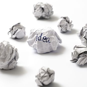 white crumpled paper ball focus idea word on a white background