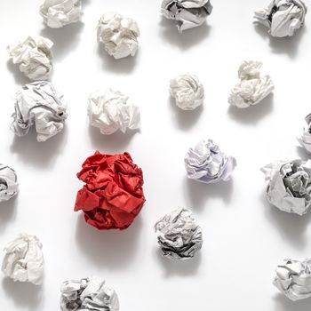 white crumpled paper ball and different red crumpled paper ball on a white background