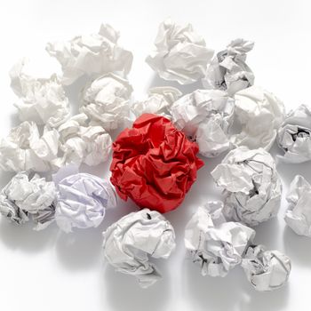 white crumpled paper ball and different red crumpled paper ball on a white background