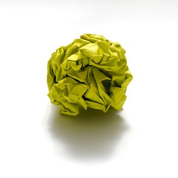 yellow color crumpled paper ball on a white background