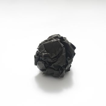 black crumpled paper ball on a white background