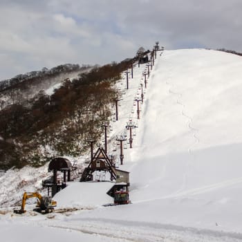 Ski chair lift with skiers on mountain