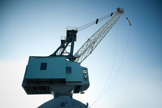 dockyard cargo crane against a gradient blue sky