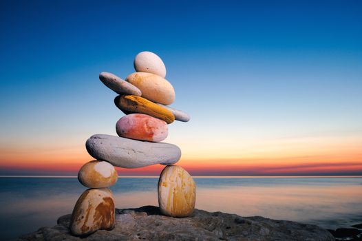 Figure of inukshuk on the seacoast against the sunset