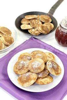 Poffertjes with powdered sugar on a light background