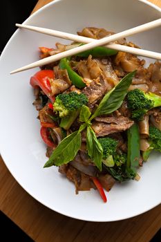 Pad kee mao drunken noodle thai dish with beef and mixed vegetables.