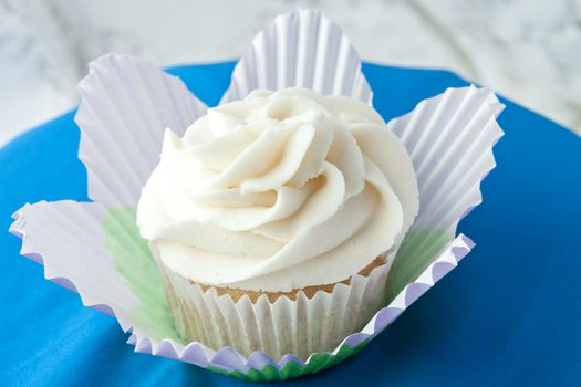 Close up of a decadent gourmet cupcake with vanilla frosting. 