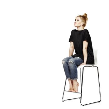 Portrait of a young woman sitting on modern chair. Isolated on white background.