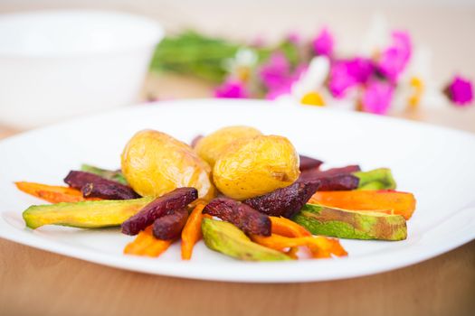 Plate ful of vegetable cooked with potato, beetroot, avocado and carrot chips