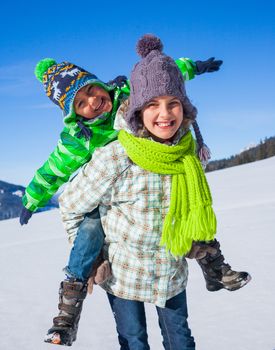 Two happy kids playing winter on the snow in Alps