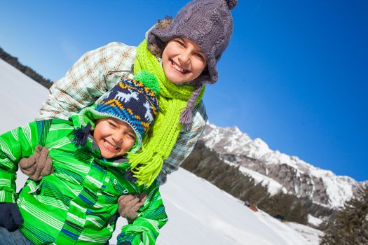 Two happy kids playing winter on the snow in Alps