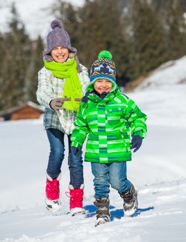 Two happy kids playing winter on the snow in Alps