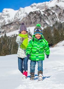 Two happy kids playing winter on the snow in Alps