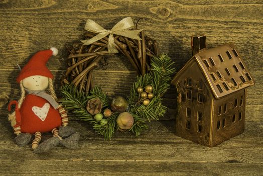 Christmas decoration with a Santa girl, wreath and a copper house for candles