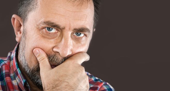 Close-up portrait portrait of a thoughtful elderly man with hand near the face