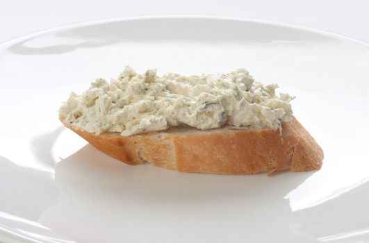 Sandwich with long loaf and cottage cheese on the white plate;