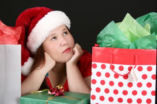 Beautiful caucasian brunette looking inside her christmas gift bag 