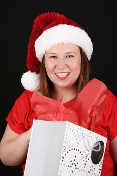 Beautiful caucasian brunette looking inside her christmas gift bag 