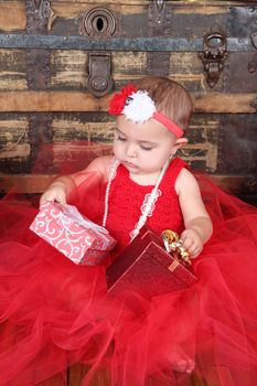 Brunette christmas baby girl wearing a long red tulle dress 