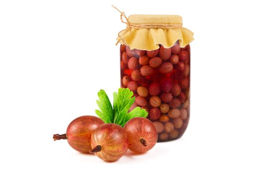 Jar of canned compote gooseberry as well as fresh berries and green leaves on a white background