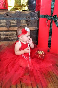 Brunette christmas baby girl wearing a long red tulle dress 