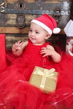 Brunette christmas baby girl wearing a long red tulle dress 