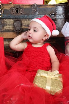 Brunette christmas baby girl wearing a long red tulle dress 