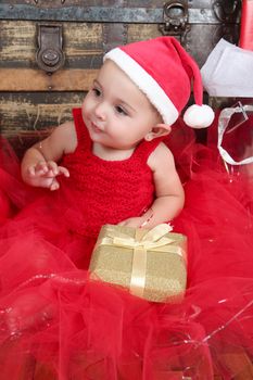 Brunette christmas baby girl wearing a long red tulle dress 