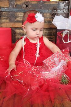 Brunette christmas baby girl wearing a long red tulle dress 