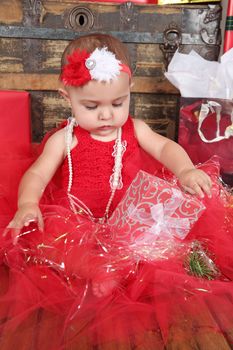 Brunette christmas baby girl wearing a long red tulle dress 