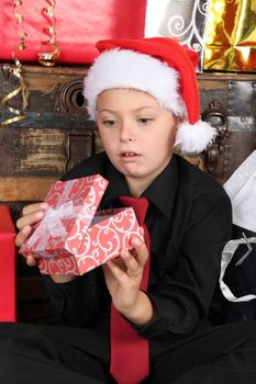 Young boy wearing a christmas hat dissapointed with gift