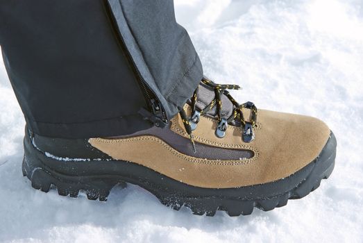 Leather boot with black laces on snow.