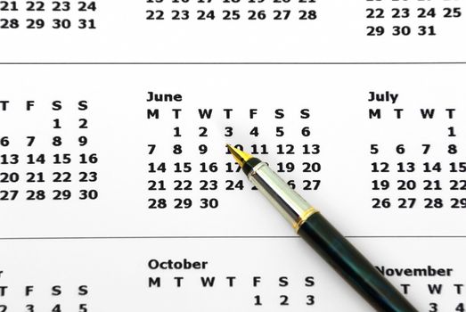 Pen and calendar isolated on a white background.