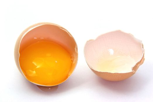 Close up image of a broken egg over white.