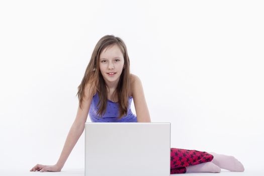 young girl sitting with laptop computer - isolated on white