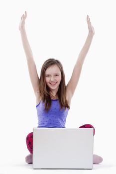 young girl sitting in front of her laptop cheering - isolated on white