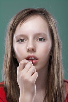 portrait of a pretty eleven years old girl putting on makeup