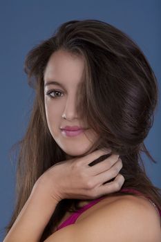 studio portrait of a beautiful brunette isolated on blue background