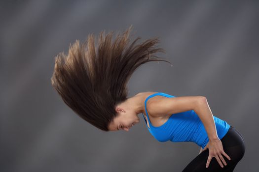 woman with long brown hair shaking her head to make it fly