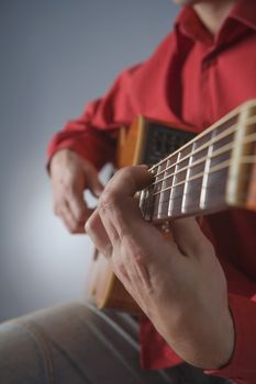 closeup of hands of a musician playing acoustic guitar