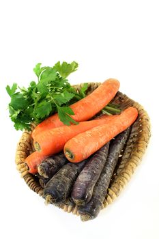 orange and purple carrots in front of white background