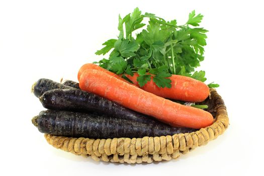 orange and purple carrots in front of white background