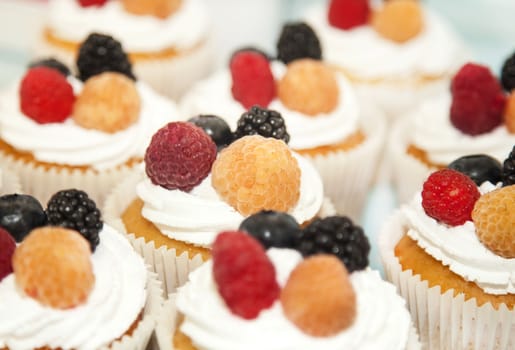 Cupcakes with white cream and berries