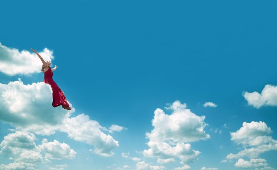 Woman sitting on the cloud. Happiness and joy concept.