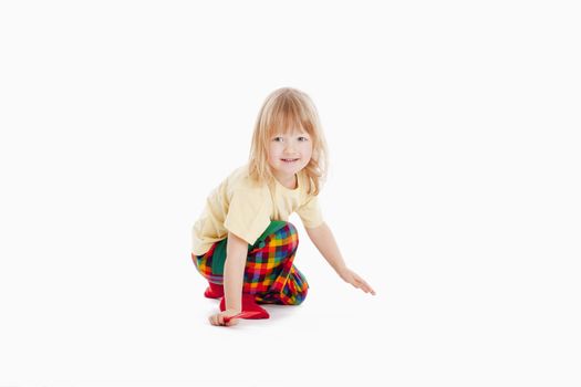 boy with long blond hair sitting, looking at camera