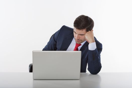 worried business executive in suit behind desk with laptop